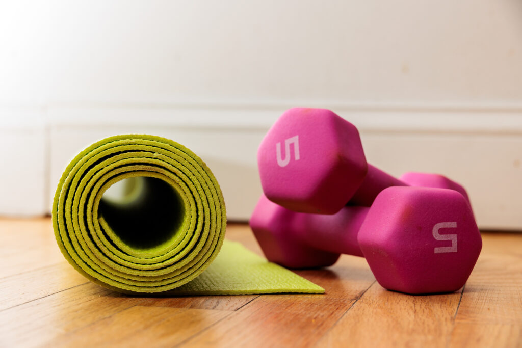 Fitness essentials: yoga mat and dumbbells ready for a workout.